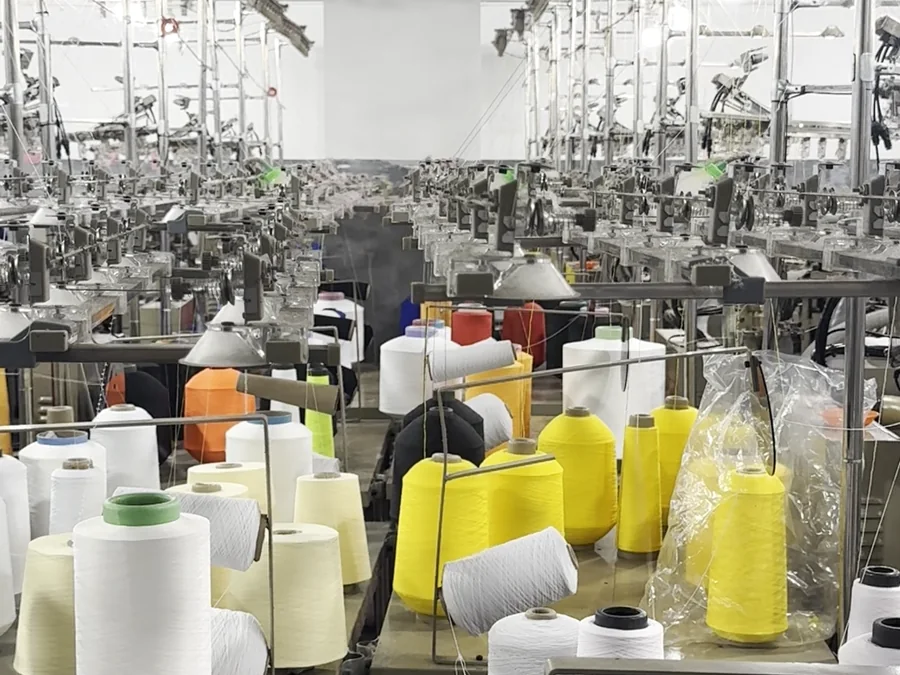 Knitting hall at our Yiwu plant: dozens of machines and yarn cones (real photo)