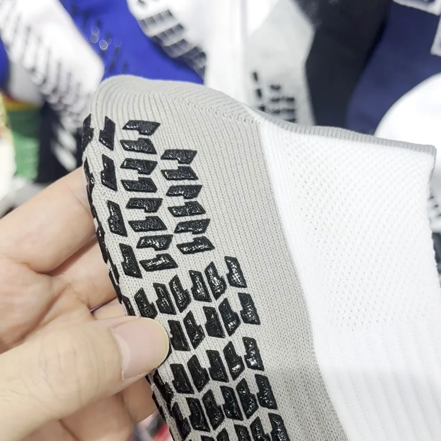 White grip sock in hand: sole with silicone dots (real factory photo)